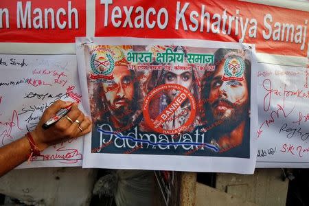 A man signs a banner during a signature campaign as part of a protest, organised by members of Bharat Kshatriya Samaj, against the release of Bollywood movie "Padmavati" in Kolkata, India, November 22, 2017. REUTERS/Rupak De Chowdhuri
