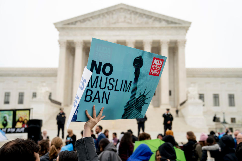 FILE - In this April 25, 2018, file photo, a person holds up a sign that reads "No Muslim Ban" during an anti-Muslim ban rally as the Supreme Court hears arguments about whether President Donald Trump's ban on travelers from several mostly Muslim countries violates immigration law or the Constitution in Washington. Six of Biden's 17 first-day executive orders dealt with immigration, such as halting work on a border wall in Mexico and lifting a travel ban on people from several predominantly Muslim countries. (AP Photo/Andrew Harnik, File)