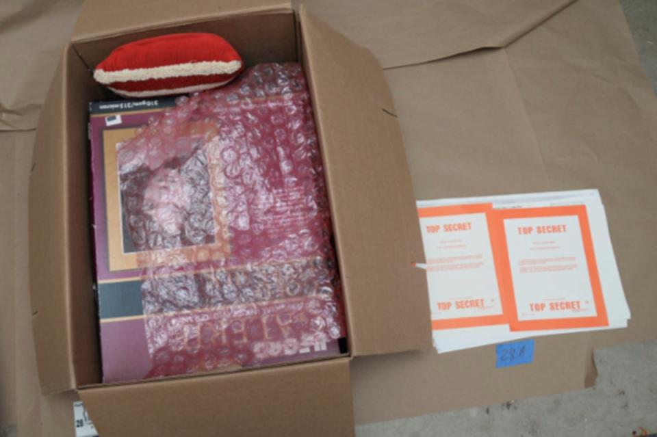 Documents marked ‘top secret’ appear next to boxes with bubble wrap and other knicknacks. (US Department of Justice)