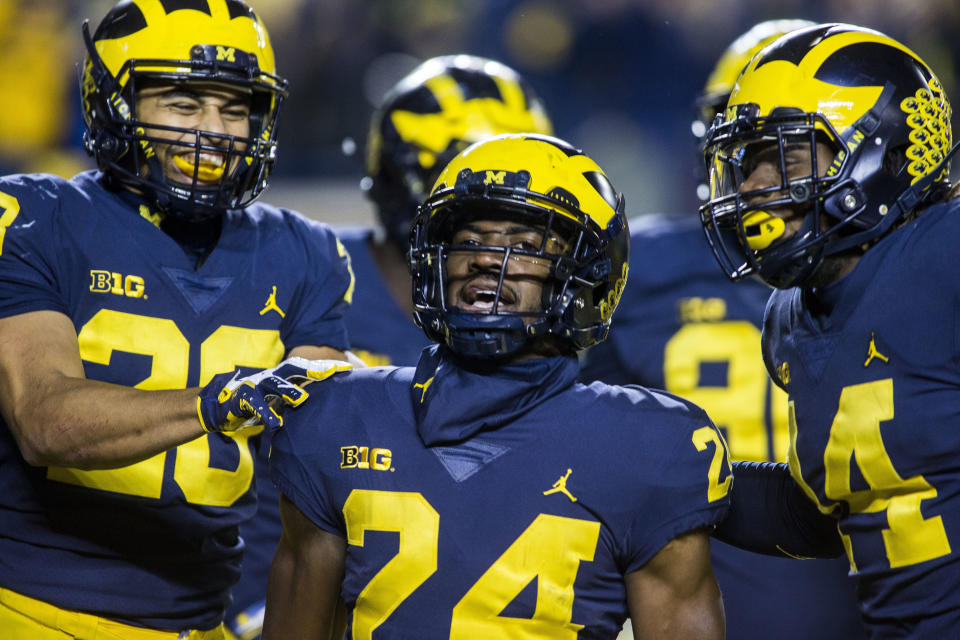 Michigan defensive back Lavert Hill (24) celebrates his touchdown interception with defensive backs Brandon Watson, left, and Josh Metellus during the fourth quarter of an NCAA college football game against Wisconsin in Ann Arbor, Mich., Saturday, Oct. 13, 2018. Michigan won 38-13. (AP Photo/Tony Ding)