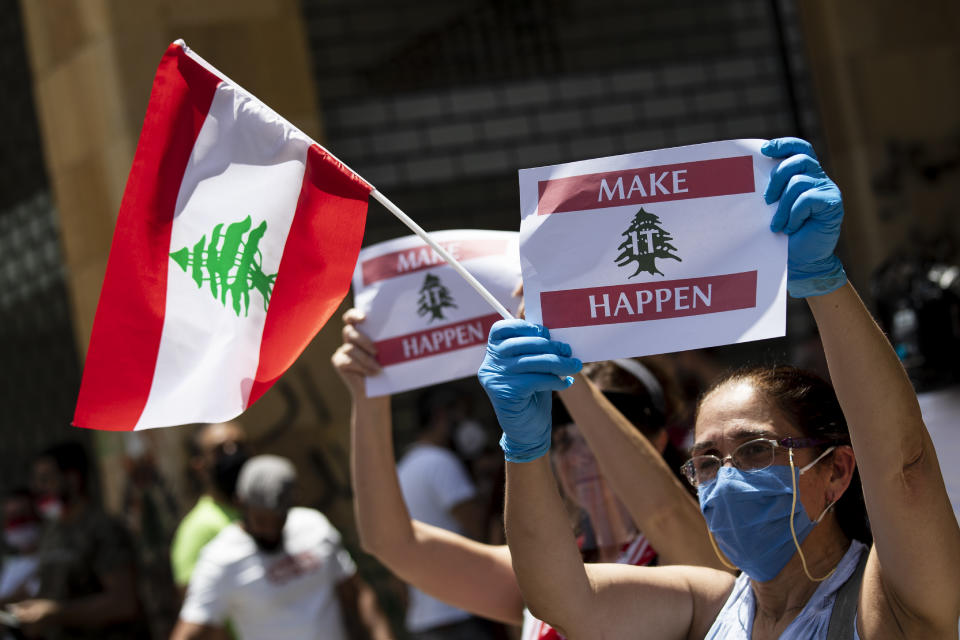 Anti-government protesters shout slogans while wearing masks to help curb the spread of the coronavirus during ongoing protests in front of the Ministry of Economy, in downtown Beirut, in Beirut, Lebanon, Monday, May 18, 2020. (AP Photo/Hassan Ammar)