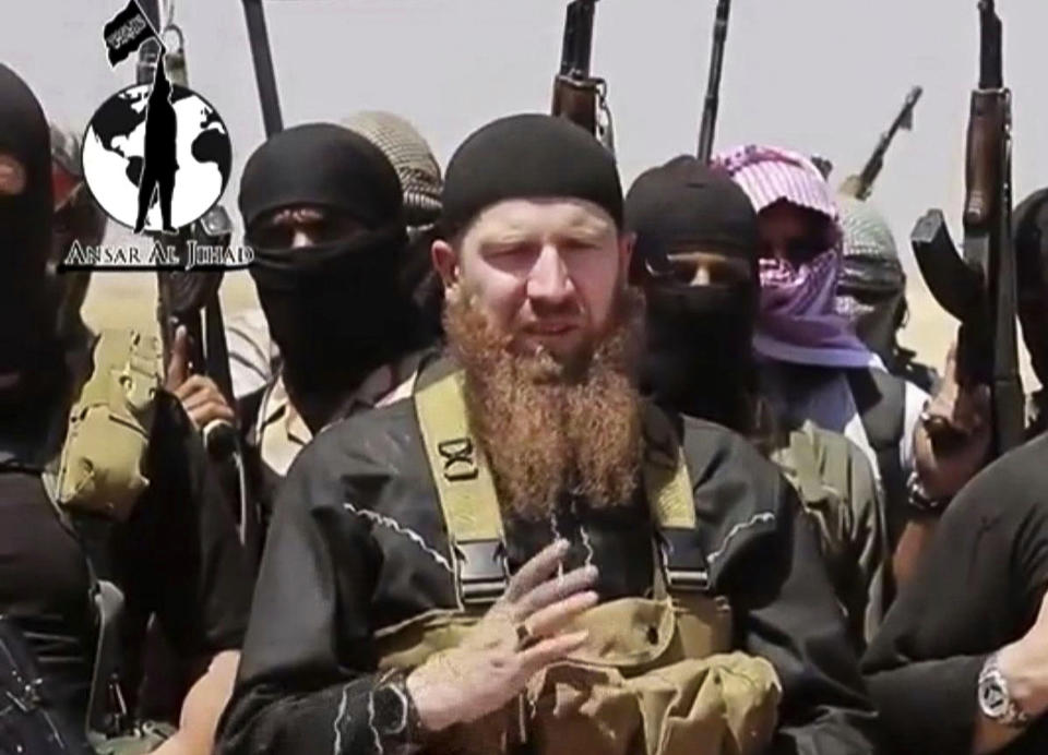 FILE - This file image made from undated video posted during the weekend of June 28, 2014, on a social media account frequently used for communications by the Islamic State of Iraq and the Levant (ISIL), which has been verified and is consistent with other AP reporting, shows Omar al-Shishani standing next to the group's spokesman among a group of fighters as they declare the elimination of the border between Iraq and Syria. (AP Photo/militant social media account via AP video, File)