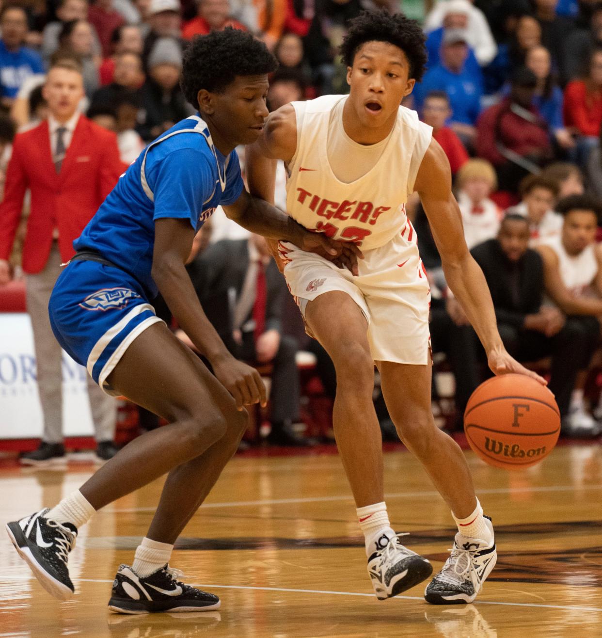 Fishers Tigers guard Jonanthony Hall (22) dribbles by Hamilton Southeastern Royals guard Deion Miles (5) on Friday, Dec. 16, 2022, at Fishers High School. 