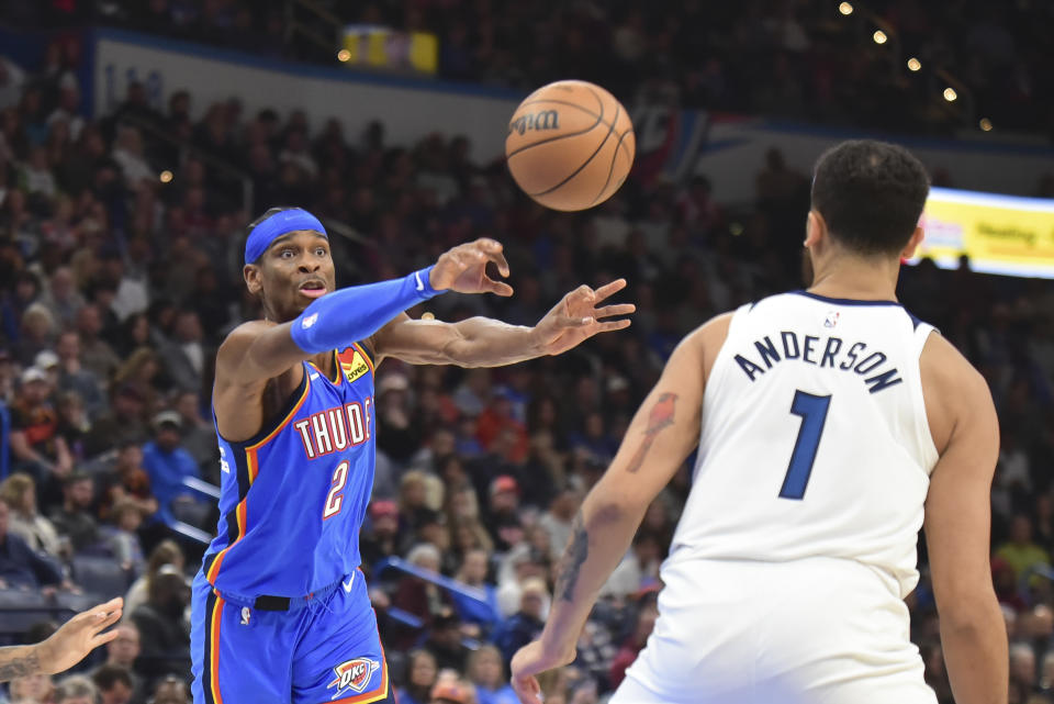 Oklahoma City Thunder guard Shai Gilgeous-Alexander (2) passes the ball past Minnesota Timberwolves forward Kyle Anderson (1) during the second half of an NBA basketball game Tuesday, Dec. 26, 2023, in Oklahoma City. (AP Photo/Kyle Phillips)