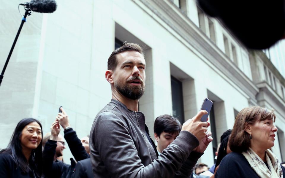 Jack Dorey, seen here as a younger man with a much neater, shorter beard and his hair swept back from a side parting, looks quizzically up away from his smartphone as he is surrounded by reporters and others outside the New York Stock Exchange  - Yana Paskova/Bloomberg