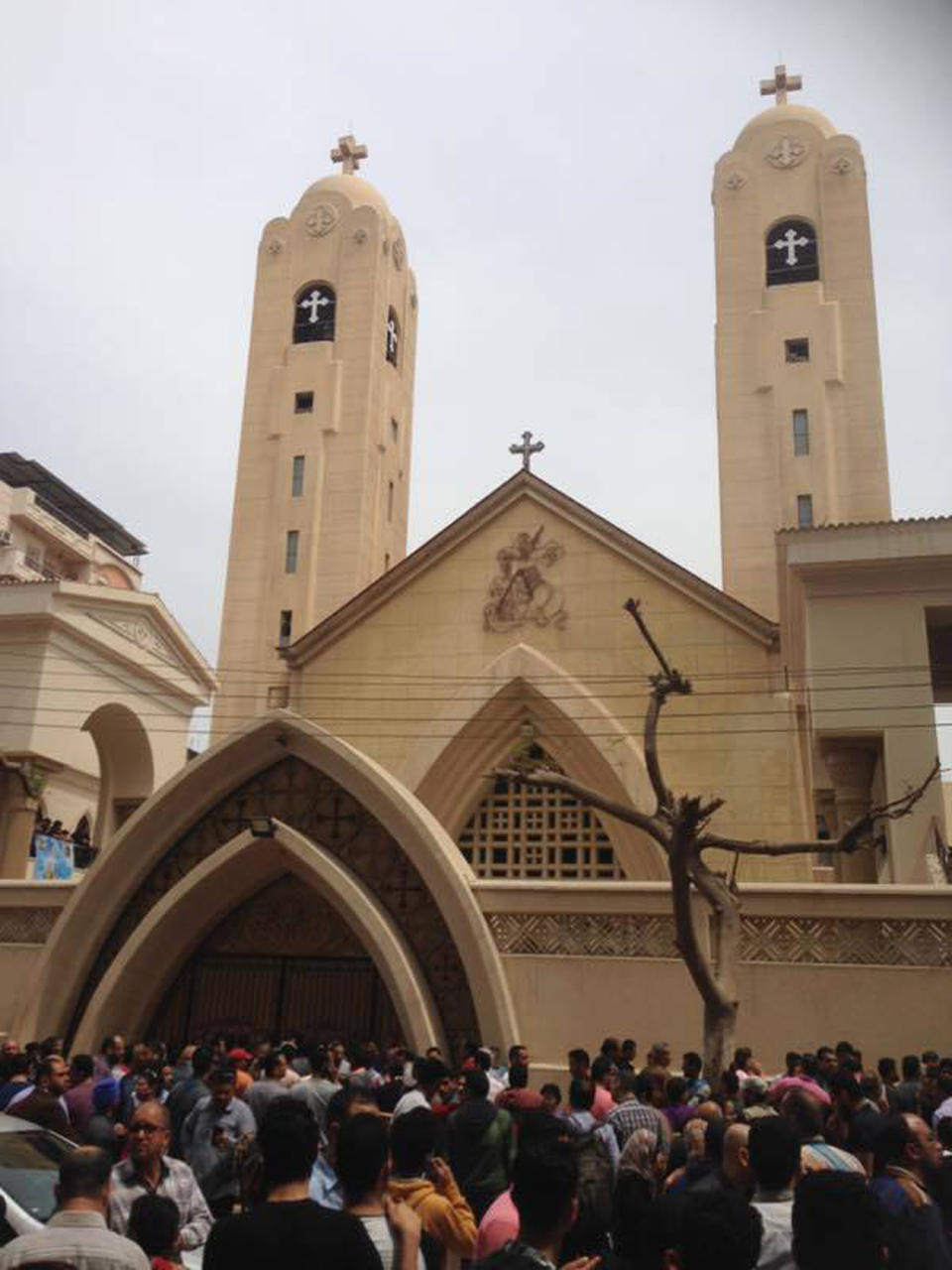 Familiares y viandantes se congregan en el exterior de una iglesia tras el estallido de una bomba en la localidad de Tanta, en el Delta del Nilo, Egipto, el 9 de abril de 2017. El ataque coincide con la celebración del Domingo de Ramos en la Iglesia copta, cuando el templo estaba lleno de fieles. (AP Foto/Ahmed Hatem)