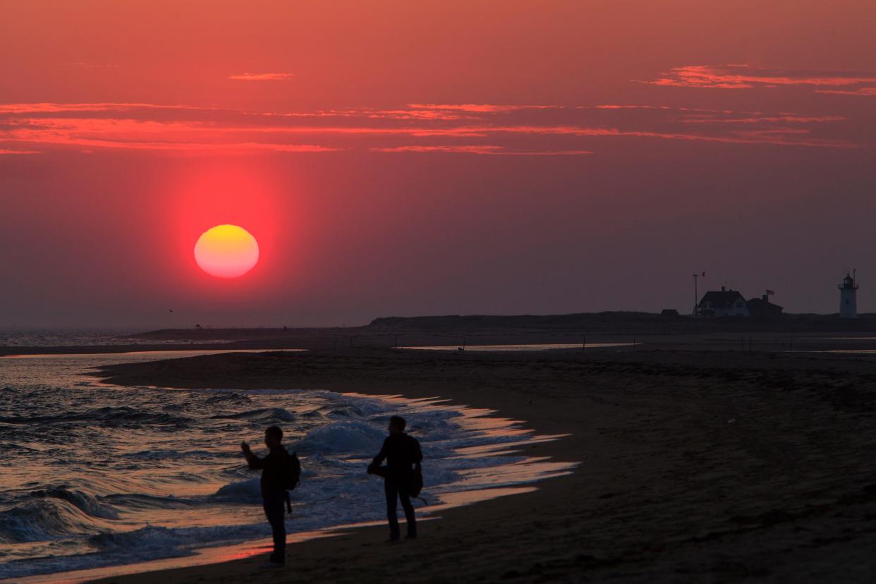 Sunset at Herring Cove Beach in Provincetown, with Race Point Light in the background.