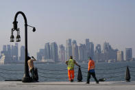 With the city skyline in the background, migrant workers rest at the Doha port, in Doha, Qatar, Sunday, Nov. 13, 2022. Final preparations are being made for the soccer World Cup which starts on Nov. 20 when Qatar face Ecuador. (AP Photo/Hassan Ammar)