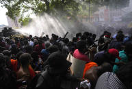 Police use tear gas and water cannons to disperse protesting members of the Inter University Students Federation during an anti government protest in Colombo, Sri Lanka, Thursday, May 19, 2022. Sri Lankans have been protesting for more than a month demanding the resignation of President Gotabaya Rajapaksa, holding him responsible for the country's worst economic crisis in recent memory. (AP Photo/Eranga Jayawardena)