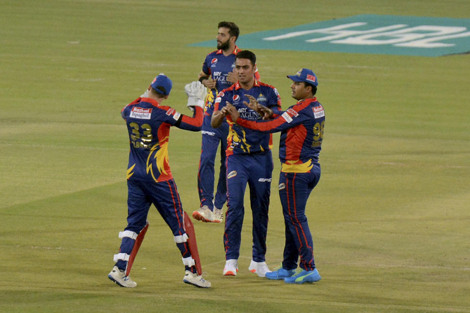 Karachi Kings Arshad Iqbal, center, celebrates with teammates after taking the wicket of Quetta Gladiators Azam Khan during a Pakistan Super League T20 cricket match between Karachi Kings and Quetta Gladiators at National Stadium, in Karachi, Pakistan, Saturday, Feb. 20 2021. (AP Photo/Fareed Khan)