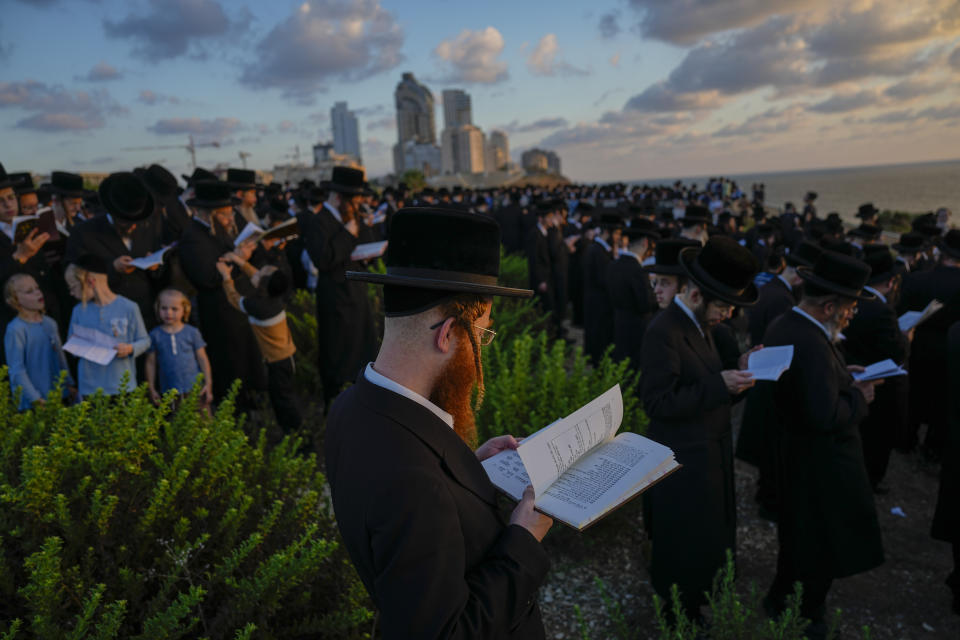 FILE - Ultra-Orthodox Jewish men of the Kiryat Sanz Hasidic sect pray on a hill overlooking the Mediterranean Sea as they participate in a Tashlich ceremony in Netanya, Israel, Thursday, Sept. 21, 2023. Israel is a nation perennially swept up in religious fervor and conflict. And yet, strikingly, a large portion of its population is secular, and even its insular ultra-Orthodox community loses a steady stream of members who tire of its strict religious rules. (AP Photo/Ariel Schalit, File)