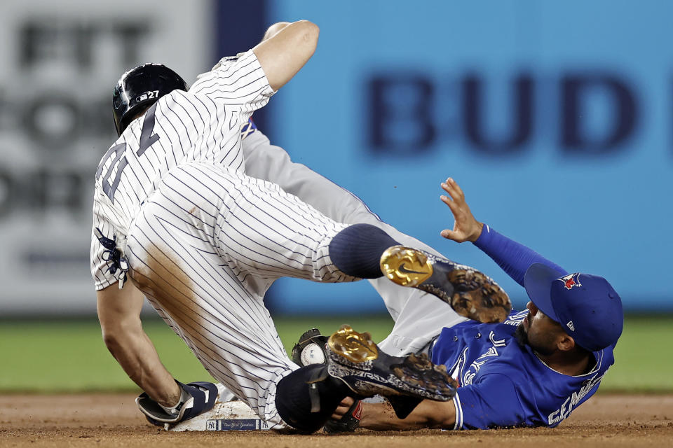 Toronto Blue Jays second baseman Marcus Semien tags out New York Yankees' Giancarlo Stanton (27), who tried to stretch a single into a double during the fourth inning of a baseball game Thursday, Sept. 9, 2021, in New York. Stanton was originally called safe but was called out after a challenge by the Blue Jays. (AP Photo/Adam Hunger)