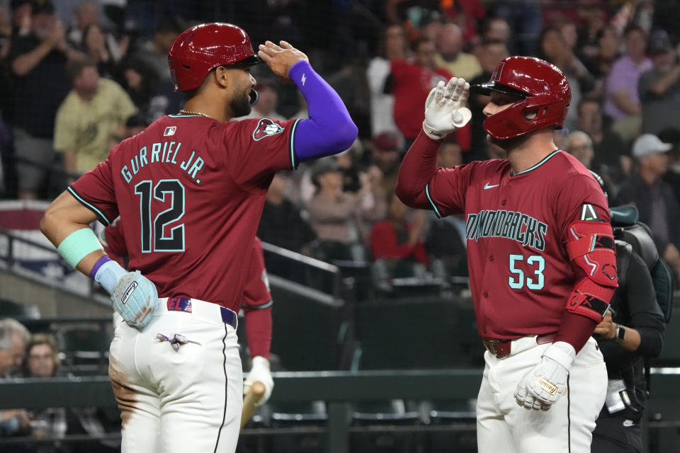 Arizona Diamondbacks' Christian Walker (53) celebrates with Lourdes Gurriel Jr. after hitting a two-run home run against the Colorado Rockies during the first inning of a baseball game Sunday, March 31, 2024, in Phoenix. (AP Photo/Rick Scuteri)