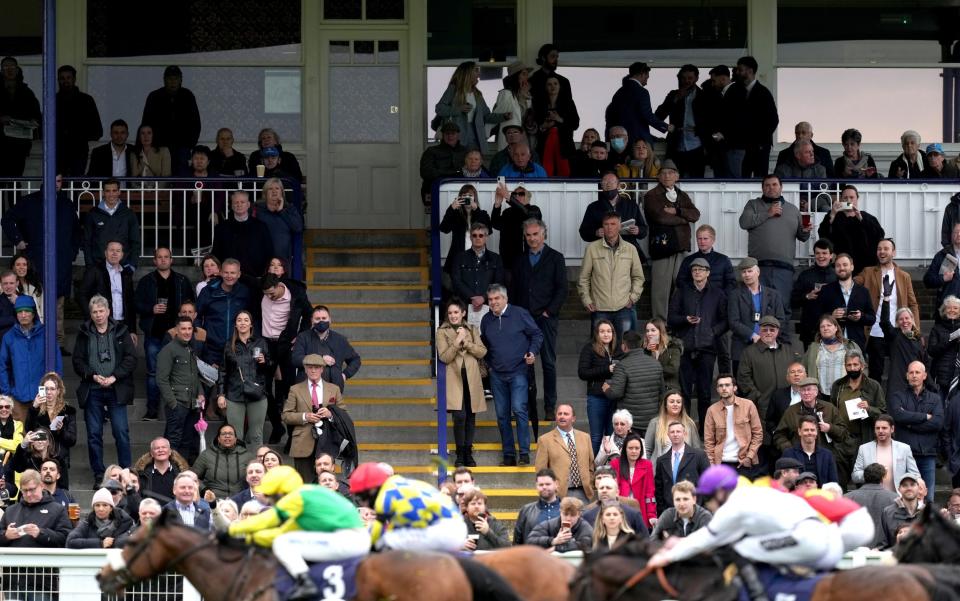  Spectators watch from the stands as Stake Acclaim (left) ridden by Callum Hutchinson comes home second in the Fitzdares Loves Royal Windsor Racecourse Handicap  - John Walton - Pool/Getty Images