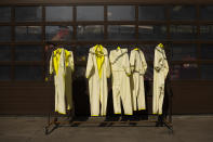 Protective suits hung after being disinfected at the firefighters headquarters in Brussels, Thursday, April 9, 2020. The new coronavirus causes mild or moderate symptoms for most people, but for some, especially older adults and people with existing health problems, it can cause more severe illness or death. (AP Photo/Francisco Seco)