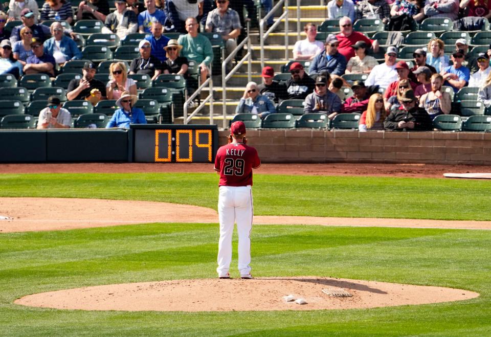 Mar 3, 2023; Scottsdale, AZ, USA; Arizona Diamondbacks starting pitcher Merrill Kelly (29) prepares to throw against Seattle Mariners in the third inning with the new pitch clock counting down during a spring training game at Salt River Fields. Mandatory Credit: Rob Schumacher-Arizona Republic