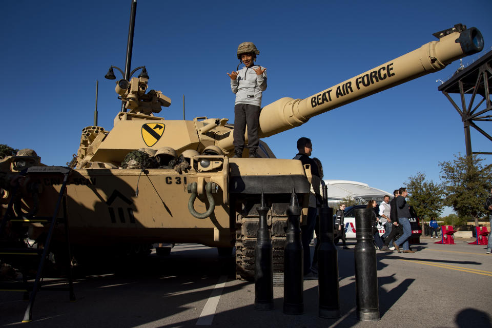 Eduardo Guerrero, 9, poses for a photo while standing on top of an tank prior that was parked outside the stadium before an NCAA college football game between Army and Air Force in Arlington, Texas, Saturday, Nov. 5, 2022. (AP Photo/Emil Lippe)