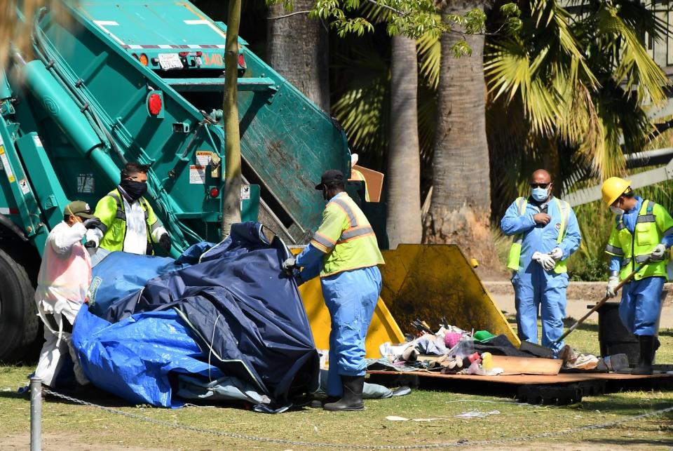 Crews moved belongings into a dump truck.