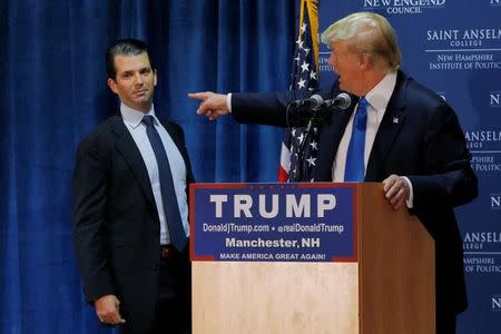 FILE PHOTO: Then U.S. Republican presidential candidate Donald Trump (R) welcomes his son Donald Trump Jr. to the stage at one of the New England Council's "Politics and Eggs' breakfasts in Manchester, New Hampshire November 11, 2015. REUTERS/Brian Snyder/Files