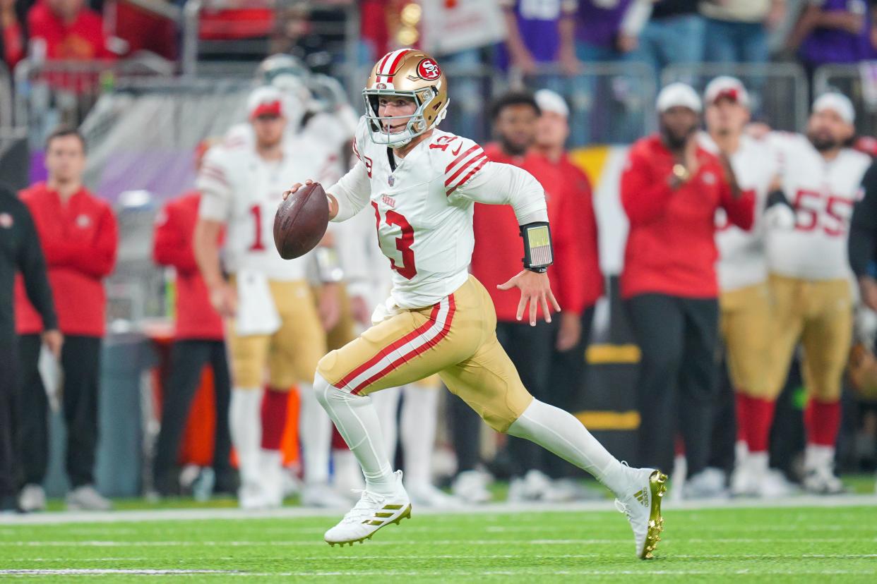 San Francisco 49ers quarterback Brock Purdy (13) scrambles against the Minnesota Vikings in the first quarter at U.S. Bank Stadium.