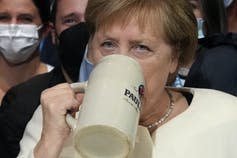 Angela Merkel sips on a beer.