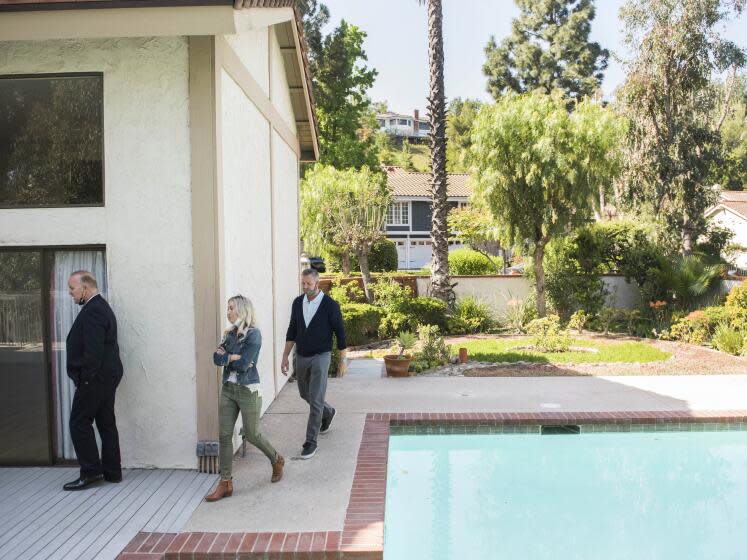 Real estate agent Derek Oie, left, shows a home to his clients Sarah and Vik Szemerei in North Tustin during their allotted 30 minute time slot on Saturday, April 17, 2021. ( Photo by Nick Agro / For The Times )