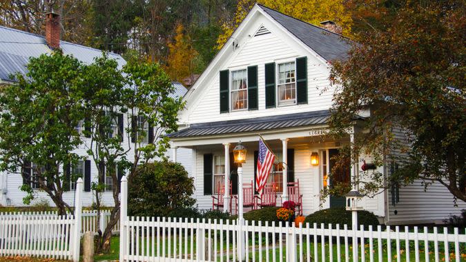 White clapboard house with a white picket fence.