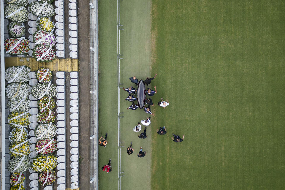 Un grupo de personas carga el féretro de Pelé en la cancha del Estadio Vila Belmiro en Santos, Brasil, el lunes 2 de enero de 2023 (AP Foto/Matias Delacroix)