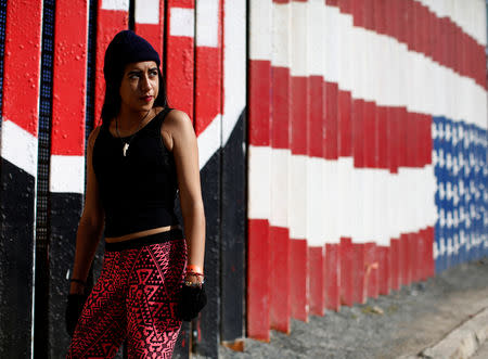 FILE PHOTO: Cristhy Alexandra Ortiz, a migrant from Honduras, part of a caravan of thousands traveling from Central America en route to the United States, poses in front of the border wall between the U.S. and Mexico in Tijuana, Mexico, November 23, 2018. REUTERS/Kim Kyung-Hoon