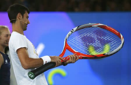 Serbia's Novak Djokovic holds a large racket during a promotional event ahead of the Australian Open tennis tournament in Melbourne, Australia, January 14, 2017. REUTERS/Edgar Su