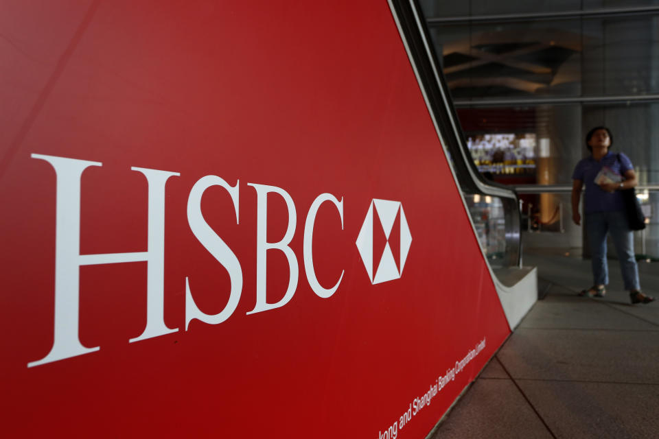 FILE -- In a July 30, 2012 file photo people walk past a logo of HSBC headquarters in Hong Kong . HSBC, the British banking giant, will pay $1.9 billion to settle a money-laundering probe by federal and state authorities in the United States, a law enforcement official said Monday Dec. 10, 2012. (AP Photo/Vincent Yu, file)