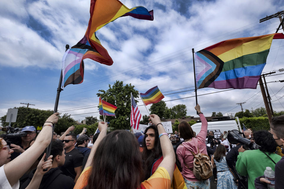 Counter-protesters wave Pride Flags as Los Angeles police officers separate them from other protesters at the Saticoy Elementary School in the North Hollywood section of Los Angeles on Friday, June 2, 2023. Police officers separated the groups Friday outside the Los Angeles elementary school that has become a flashpoint for Pride Month events and activities across California. (AP Photo/Richard Vogel)