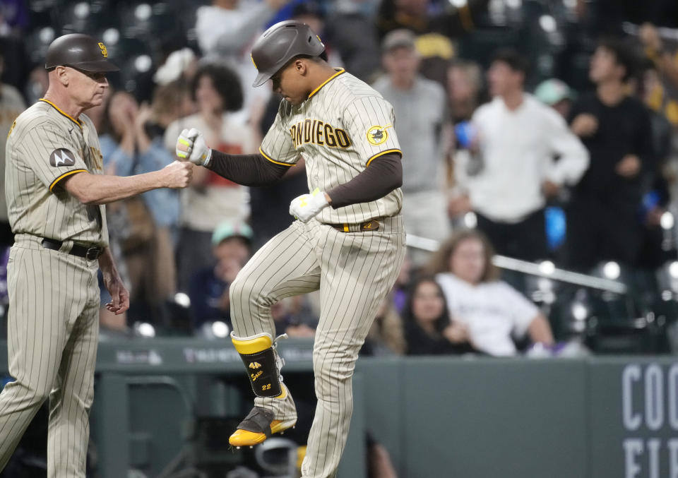 San Diego Padres third base coach Matt Williams, left, congratulates Juan Soto as he circles the bases after hitting a three-run home run against Colorado Rockies relief pitcher Tommy Doyle in the fifth inning of a baseball game Tuesday, Aug. 1, 2023, in Denver. (AP Photo/David Zalubowski)