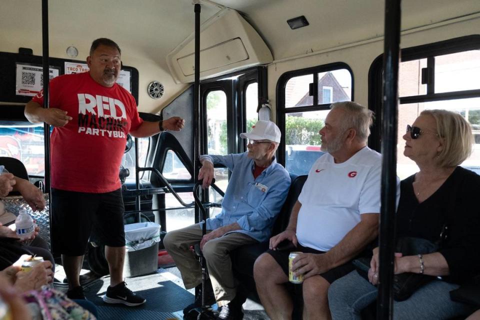 Mark Coronado, one of the Red Machine Party Bus business partners, chats with Taco Trail Tour riders Wednesday on board the Red Machine Party Bus.