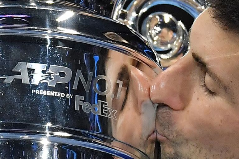 El serbio Novak Djokovic celebra con el trofeo de jugador número 1 de la ATP después de vencer al noruego Casper Ruud durante su único partido de la primera ronda de las Finales ATP en el Pala Alpitour de Turín el 15 de noviembre de 2021 (Foto de Marco BERTORELLO / AFP).