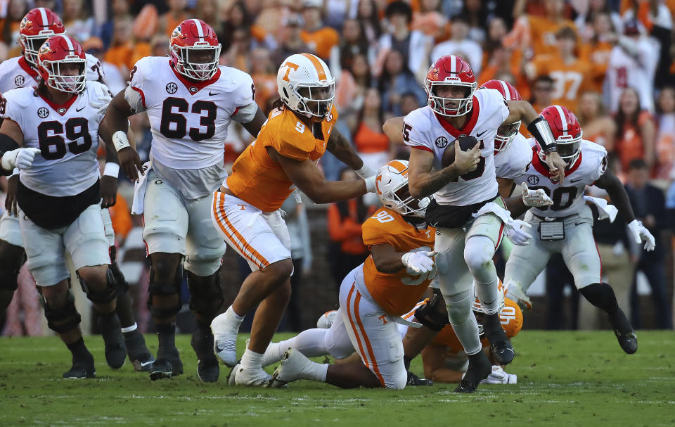 Georgia quarterback Brock Bowers breaks free from Tennessee defenders for a first down during the first quarter of an NCAA college football game, Saturday, Nov. 18, 2023, in Knoxville, Tenn. (Curtis Compton/Atlanta Journal-Constitution via AP)