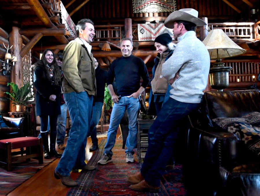FILE - Montana Gov. Steve Bullock, foreground from left, appears with actor Kevin Costner, production designer Ruth De Jong and writer-director Taylor Sheridan in the lodge at the Chief Joseph Ranch during a visit to the set of the television series "Yellowstone" in Darby, Mont, Dec. 7, 2017. The popular television western “Yellowstone” will end this fall and be replaced almost immediately by a sequel. (Kurt Wilson/The Missoulian via AP)