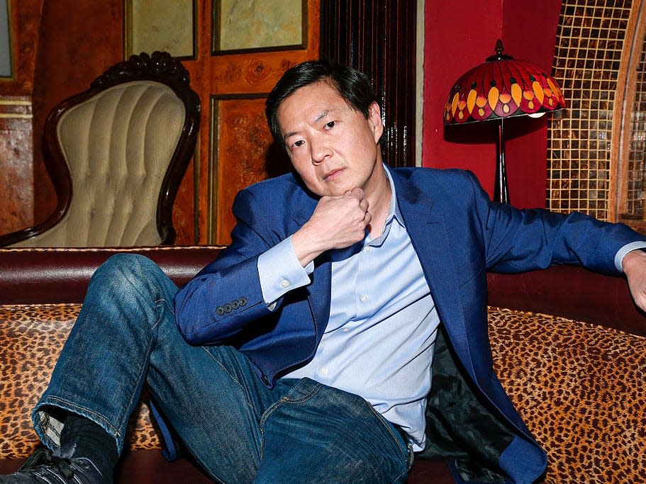 Ken Jeong wears a blue blazer and jeans with a thoughtful expression