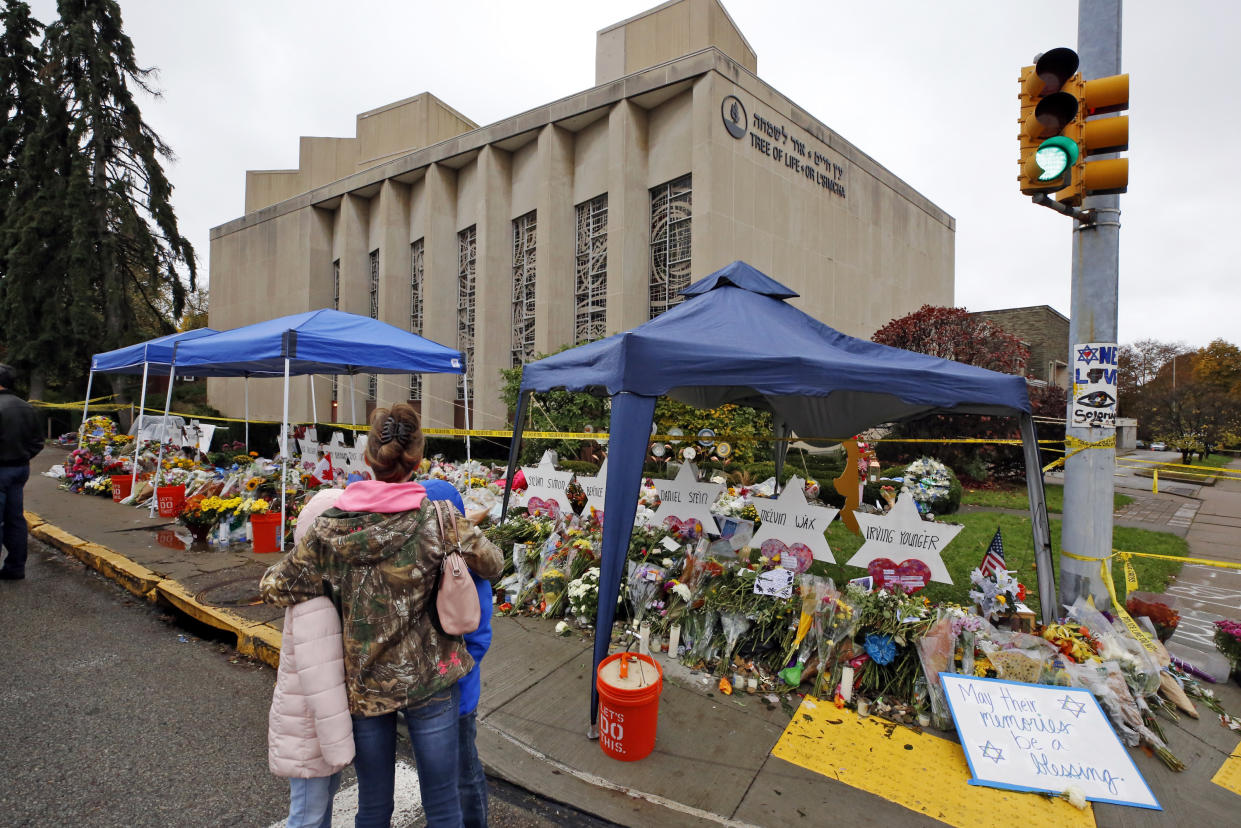 A woman and her children pause Saturday, Nov. 3, 2018, to take in a makeshift memorial outside the Tree of Life Synagogue honoring the 11 people killed Oct 27, 2018 while worshipping in the Squirrel Hill neighborhood of Pittsburgh. (AP Photo/Gene J. Puskar)