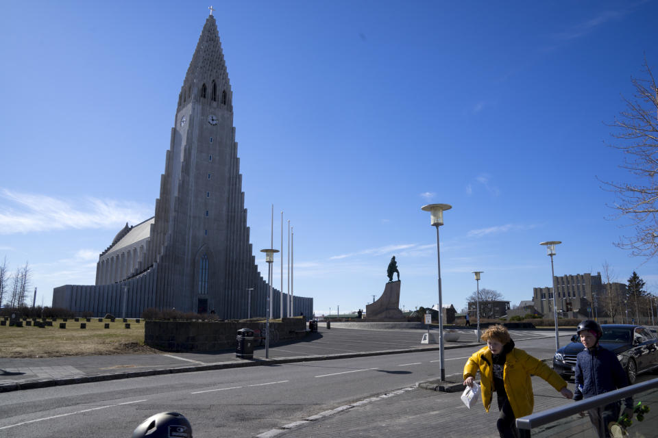 In this photo taken on Wednesday, April 29, 2020, two local boys walk past the the empty plaza of Hallgrimskirkja Church, a popular tourist destination in downtown Reykjavik. High schools, dentists and hair salons are about to reopen in Iceland, which has managed to get a grip on the coronavirus through the world’s most extensive regime of testing. By identifying infected people even when they had no symptoms, the tiny North Atlantic nation managed to identify and isolate cases where many bigger countries have struggled. (AP Photo/Egill Bjarnason)