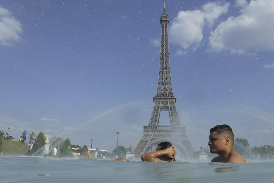 People cool off in the fountain of the Trocadero, as the Eiffel Tower is visible in background, in Paris, Tuesday, June 25, 2019. Authorities warned that temperatures could top 40 degrees Celsius (104 Fahrenheit) in some parts of Europe over the coming days, the effect of hot air moving northward from Africa. French Health Minister Agnes Buzyn said more than half of France is on alert for high temperatures Tuesday and the hot weather is expected to last until the end of the week. (AP Photo/Alessandra Tarantino)