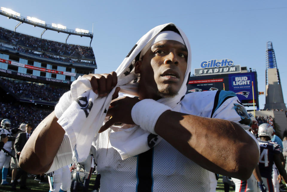 Cam Newton leaves the field with a towel on his head.