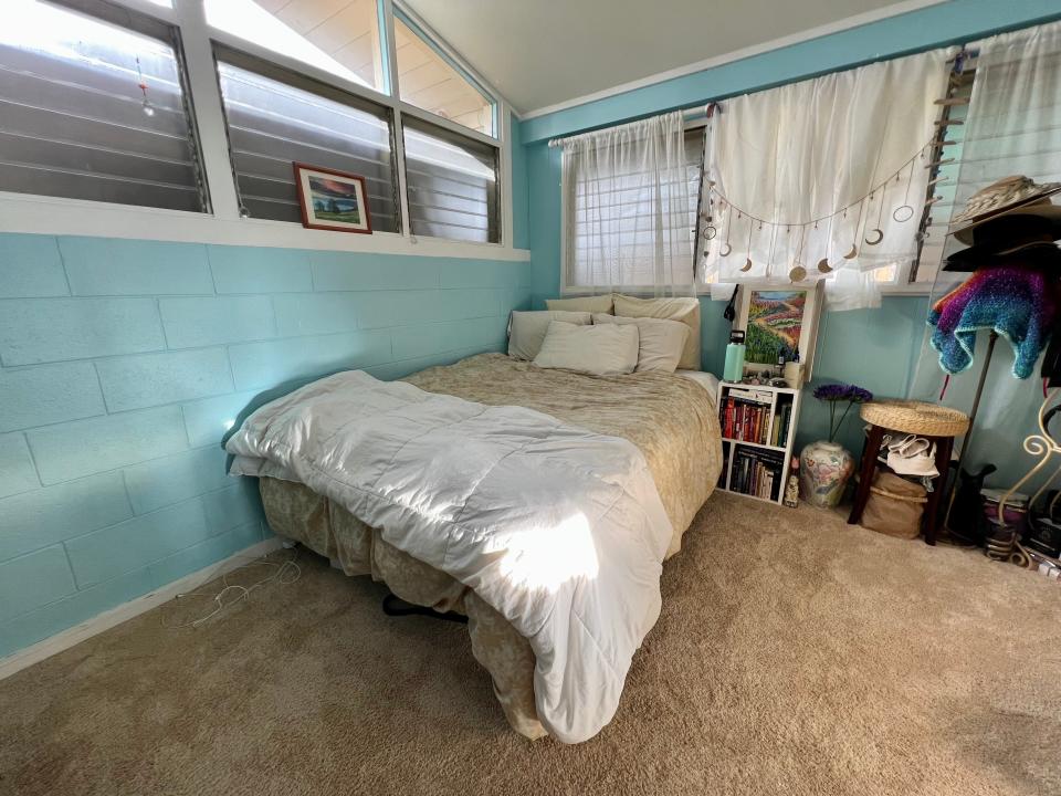 bed with no headboard or footboard against blue wall