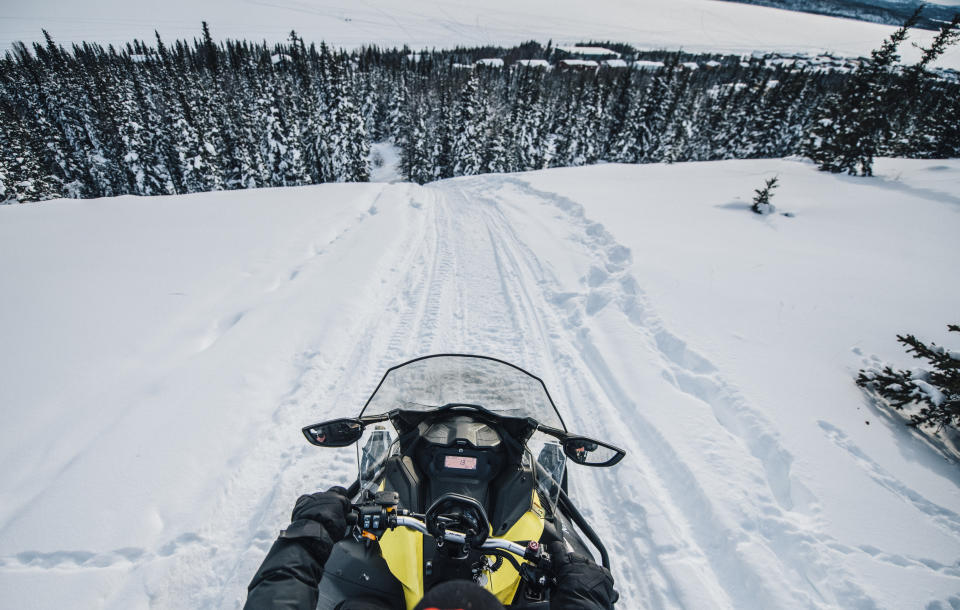 Going down a large hill on the back of a snowmobile in the Thaidene N&euml;n&eacute; Indigenous Protected Area. (Photo: Angela Gzowski for HuffPost)