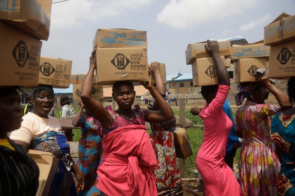 Residents of Oworonshoki Slum carry their food parcels distributed by the Lagos Food Bank Initiative, a nonprofit nutrition-focused initiative committed to fighting hunger and solving problems of malnutrition for poor communities, in Lagos, Nigeria, on July 10, 2021. Two U.N. food agencies issued stark warnings on June 6, 2022, about multiple, looming food crises on the planet, driven by climate “shocks” such as drought and worsened by the repercussions of the COVID-19 pandemic and the war in Ukraine that have sent fuel and food prices soaring.