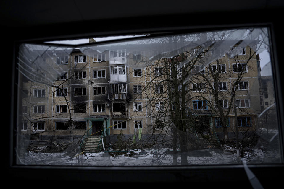 A residential building which was destroyed by Russian forces is seen through the broken window, in the frontline city of Vuhledar, Ukraine, Saturday, Feb. 25, 2023. (AP Photo/Evgeniy Maloletka)