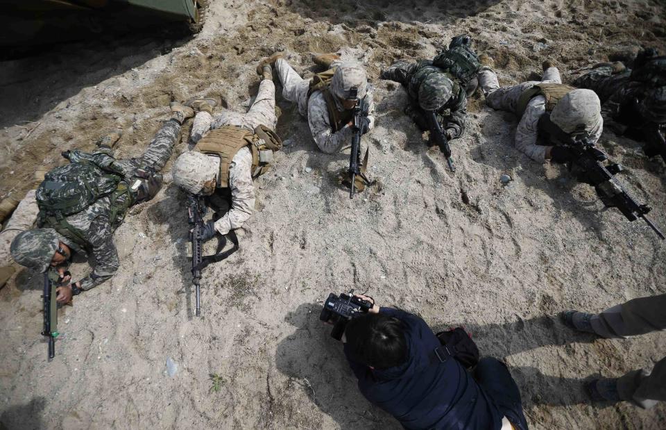 A journalist films as U.S. and South Korean marines participate in a U.S.-South Korea joint landing operation drill in Pohang March 31, 2014. (REUTERS/Kim Hong-Ji)