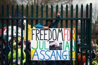 Un hombre hace un gesto detrás de una puerta en apoyo del fundador de Wikileaks, Julian Assange, ante el Tribunal de la Corona de Woolwich, antes de una audiencia para decidir si Assange debe ser extraditado a los Estados Unidos, en Londres, Reino Unido