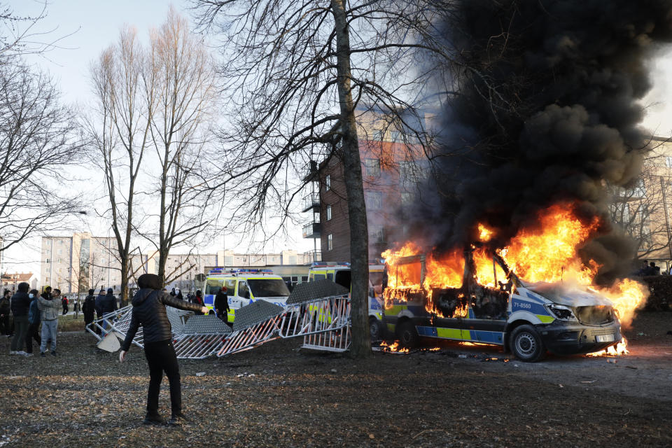 Protesters set fire to a police bus in the park Sveaparken in Orebro, Sweden, Friday, April 15, 2022. Police in Sweden say they are preparing for new violent clashes following riots that erupted between demonstrators and counter-protesters in the central city of Orebro on Friday ahead of an anti-Islam far-right group’s plan to burn a Quran there. (Kicki Nilsson/TT via AP)