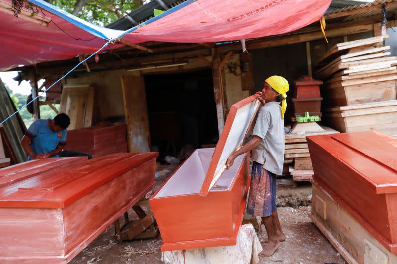 Suherman, a 45-year-old coffin maker, prepares a coffin ordered to be donated for the coronavirus disease (COVID-19) victims at a workshop inside a funeral complex in Jakarta